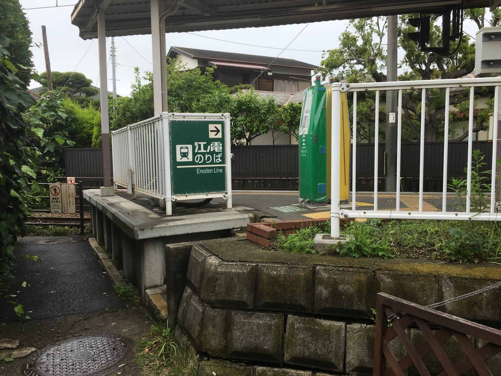 Green and yellow standalone IC card readers on the platform of Wadazuka Station on the Enoden line