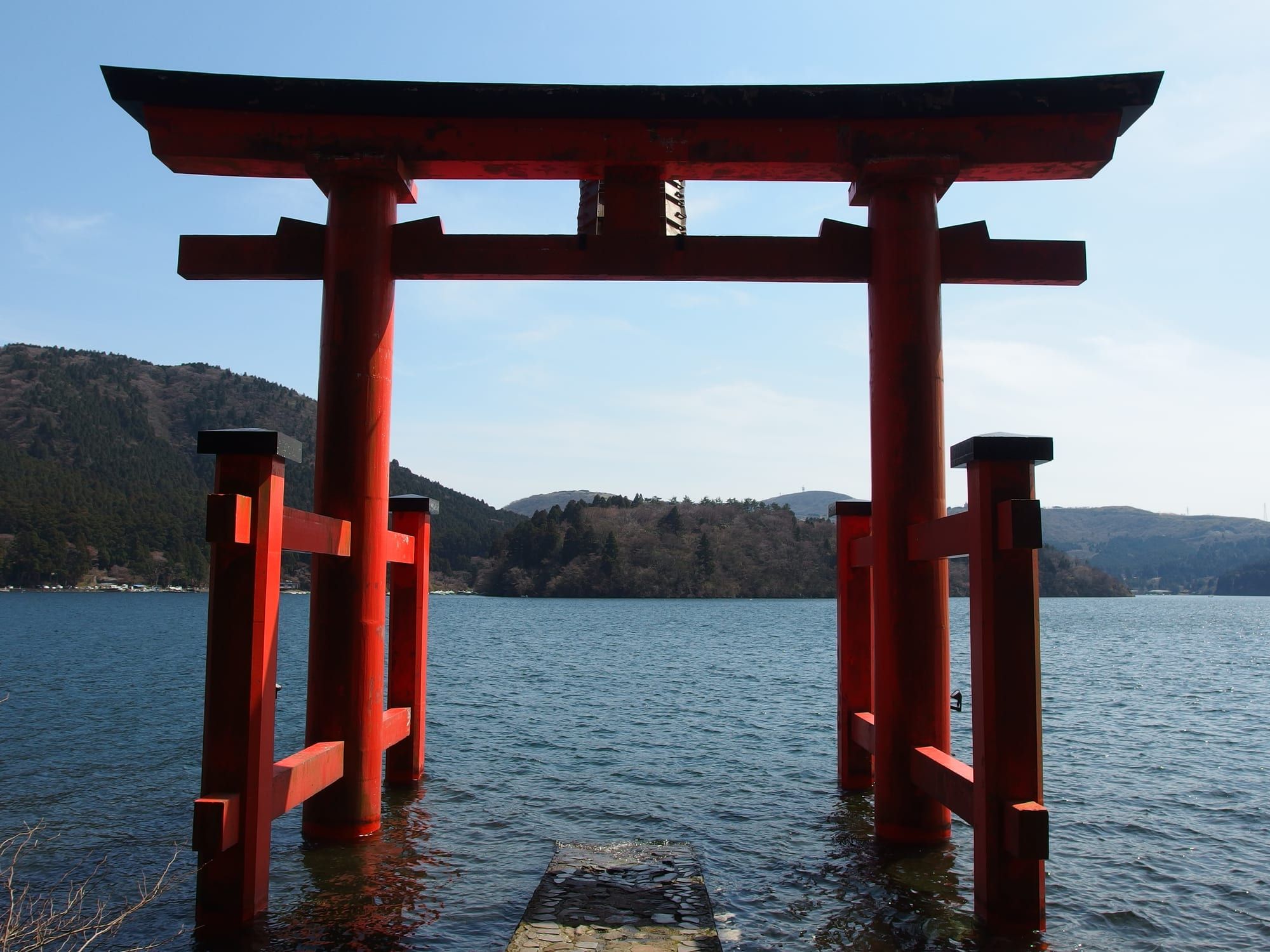 The red Heiwa-no-Torii gate of Hakone Shrine standing in the water of Lake Ashi